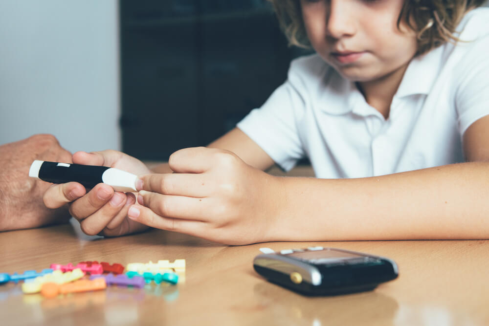 Young diabetic patient is using a lancing device